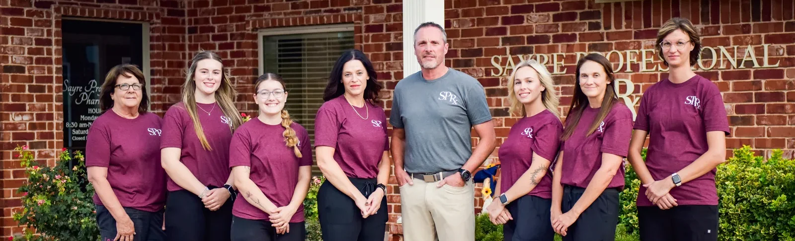 The Sayre Professional Pharmacy team standing together outside the pharmacy.